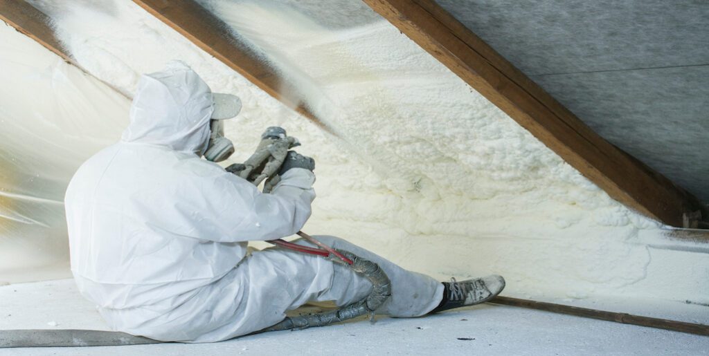 Man Installing Spray Foam Roof Insulation in Attice