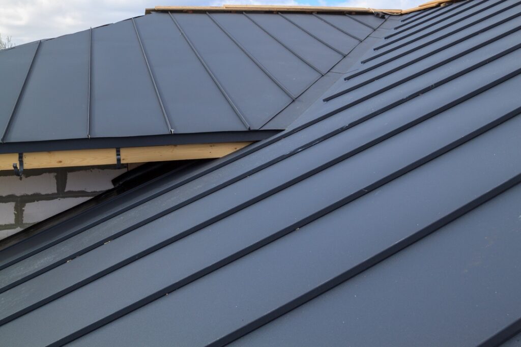 close up view of house under construction with grey folding roof on waterproofing layer