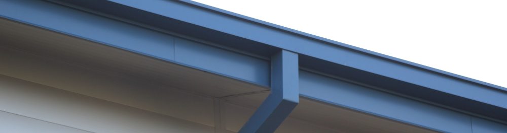 A close up image of a gutter system, the gutter material is blue to match the roof